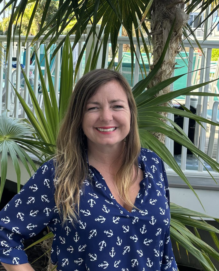 Chasity Williams, personal concierge for Stay The Keys, outdoors under a palm in Key West