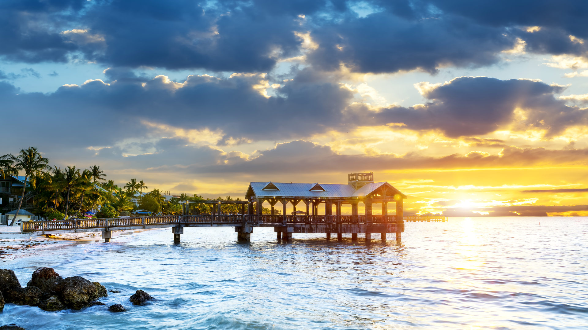 Key West pier at sunset framed by palm trees